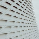 Abstract view of a white geometric building facade with grid pattern design.