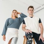 A fashionable studio portrait featuring two models with prosthetic legs posing confidently.