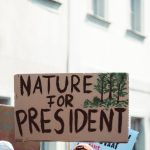 Sign at a climate protest advocating for environmental priorities with text 'Nature for President.'