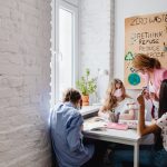 A teacher instructs teenagers on environmental conservation in a classroom setting, emphasizing zero waste practices.