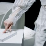 Woman in sleek attire operates cutting-edge laboratory equipment in a tech-focused environment.