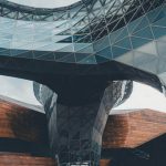 Dynamic view of a modern architectural structure featuring glass and steel elements.