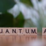 Wooden letter tiles spelling 'Quantum AI' on a blurred background.