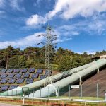 Solar panels and industrial pipes in Geesthacht's EnergiePark on a sunny day.