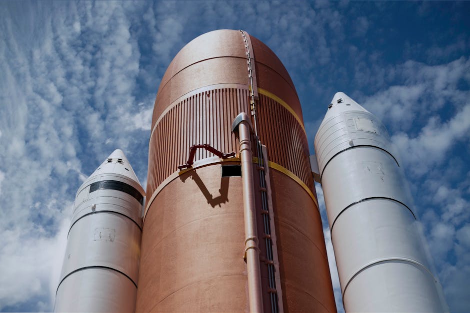 Dramatic view of rocket boosters against a bright blue sky, showcasing aerospace technology.