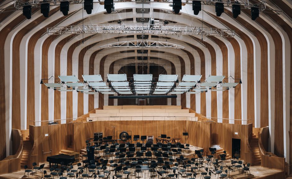 Spacious modern auditorium featuring wooden interior architecture and empty seating.