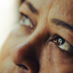 Intimate close-up shot of a woman's eyes reflecting deep thought and emotion.
