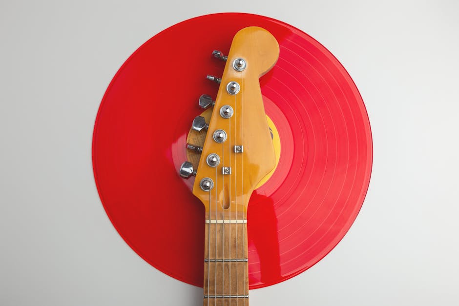Creative close-up of an electric guitar headstock with a red vinyl record. Perfect for music-themed designs.