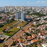 Aerial view of Londrina's cityscape featuring high-rise buildings and residential areas under a clear sky.