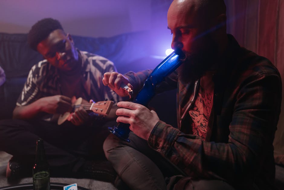 Two friends enjoying music and smoking indoors, capturing a relaxed atmosphere with a musical instrument and smoke.