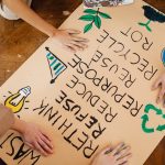 Children making an eco-friendly poster promoting recycling and waste reduction.