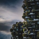Innovative green architecture featuring lush plants growing on a modern urban skyscraper facade.