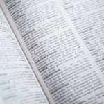 Close-up view of an open Russian dictionary showing detailed text and entries.