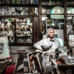 A vintage pharmacy displaying books, portraits, and a pharmacist in a reflective setting.