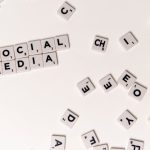 Scrabble tiles spelling 'Social Media' on a white background, symbolizing digital communication.