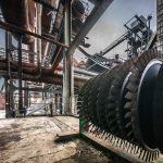 Detailed view of large industrial machinery in a factory with steel structures and pipes.