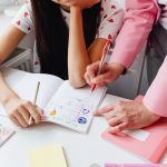 A child working on homework with assistance from an adult, focusing on learning and education.