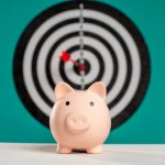 Piggy bank with bullseye dart board symbolizing financial goals and savings.