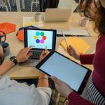 Creative meeting with digital devices in a modern office, showcasing teamwork and collaboration.