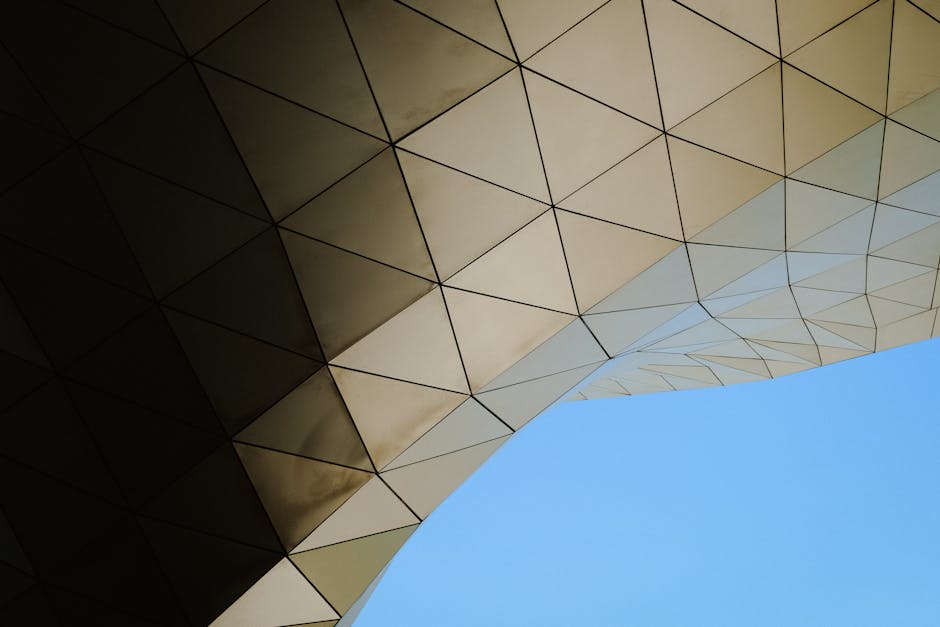A striking view of modern architecture featuring a geometric pattern against a clear blue sky.