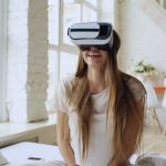 Woman enjoying virtual reality experience at home, smiling and relaxed.