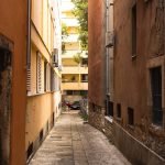 Narrow urban alleyway with rustic orange and brown walls, capturing an authentic city scene.