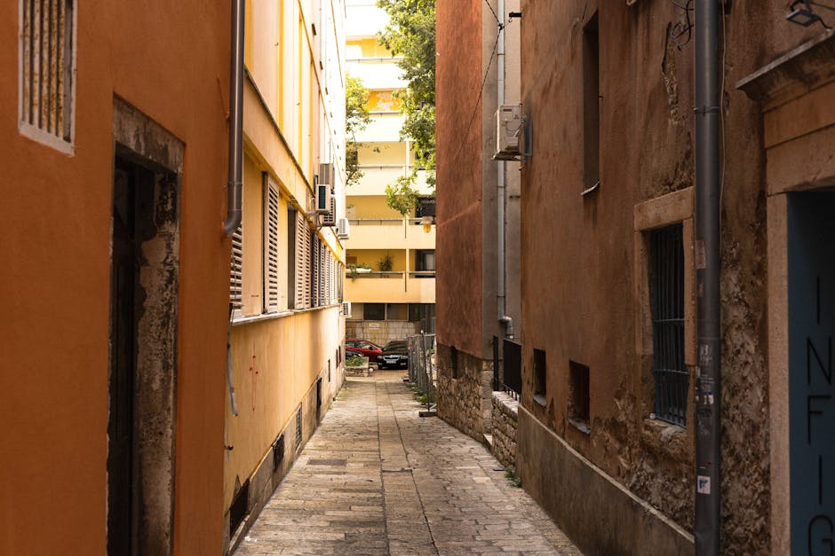 Narrow urban alleyway with rustic orange and brown walls, capturing an authentic city scene.